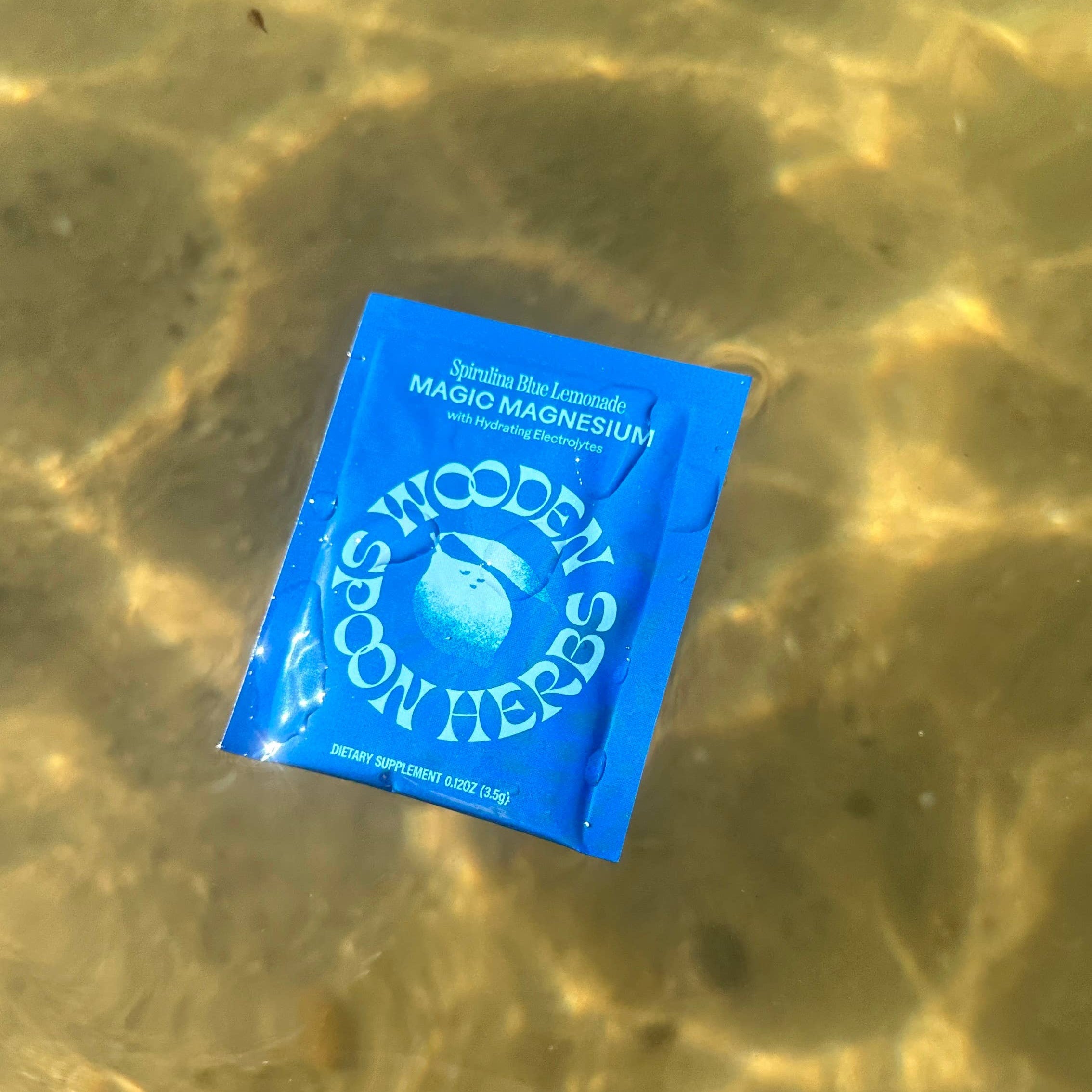 Blue packet with text floating in clear water