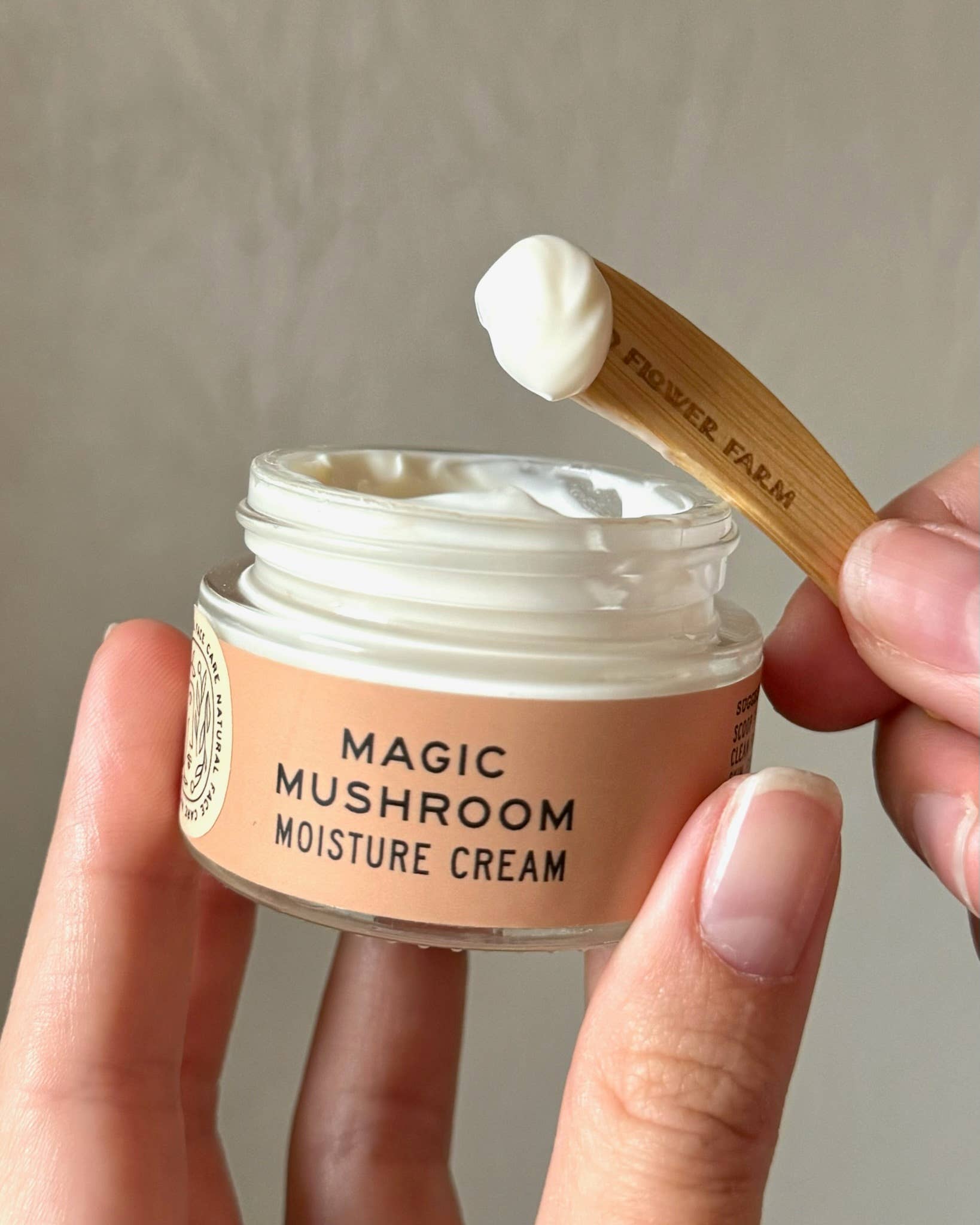 Jar of 'Magic Mushroom Moisture Cream' with a wooden applicator on a neutral background