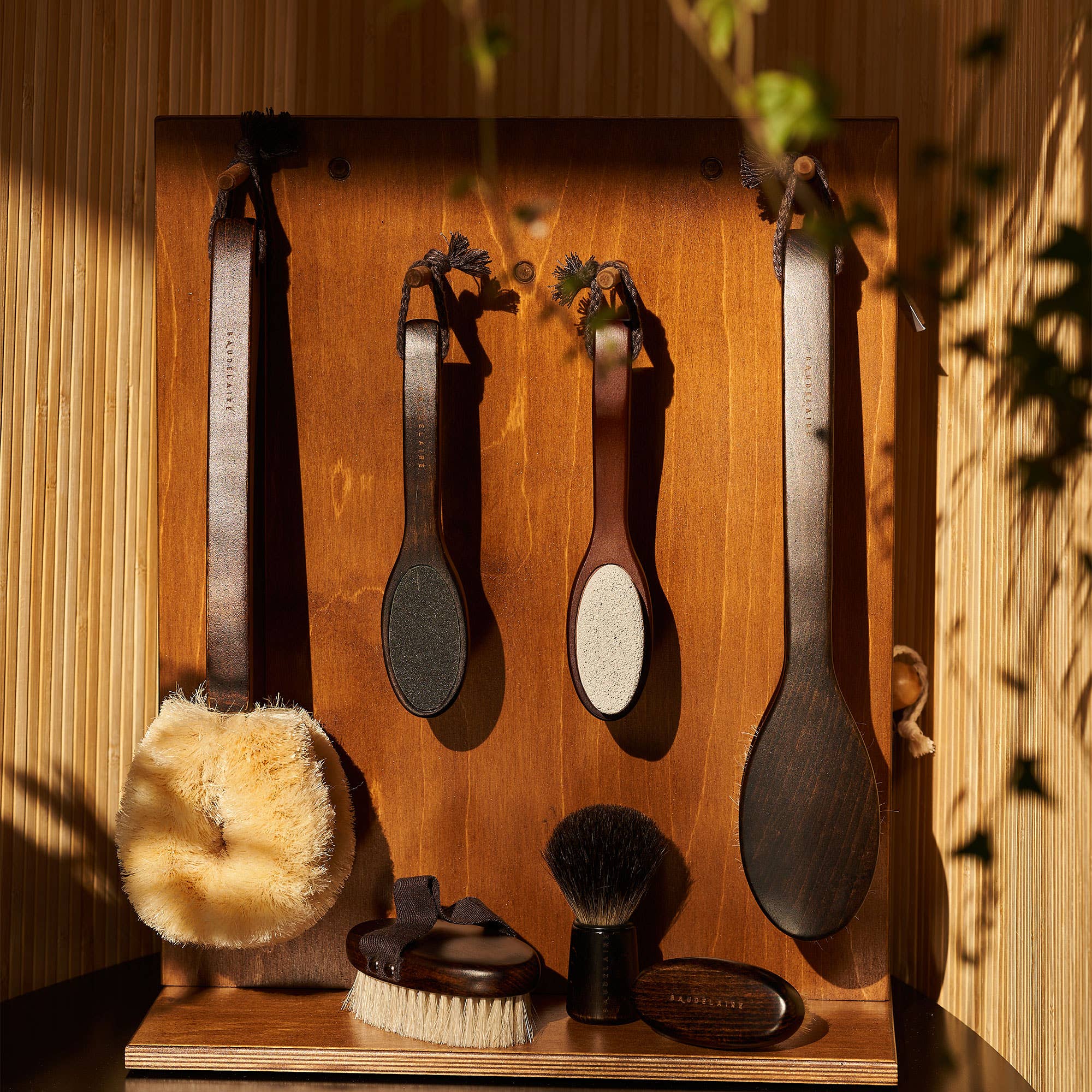 Set of grooming tools including brushes and a scrubber on a wooden stand with a warm, natural light setting.