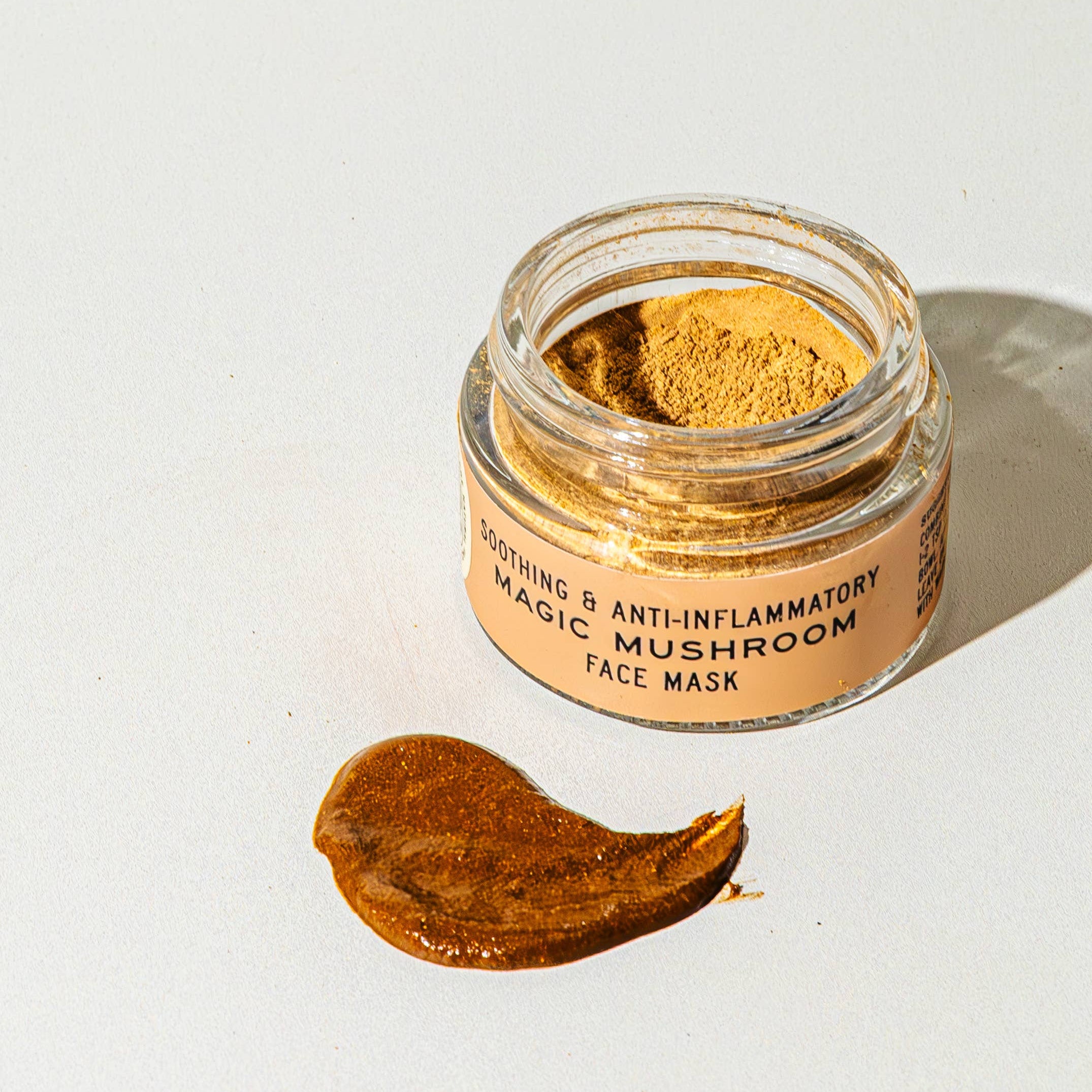 Jar of magic mushroom face mask with a swatch on a white background