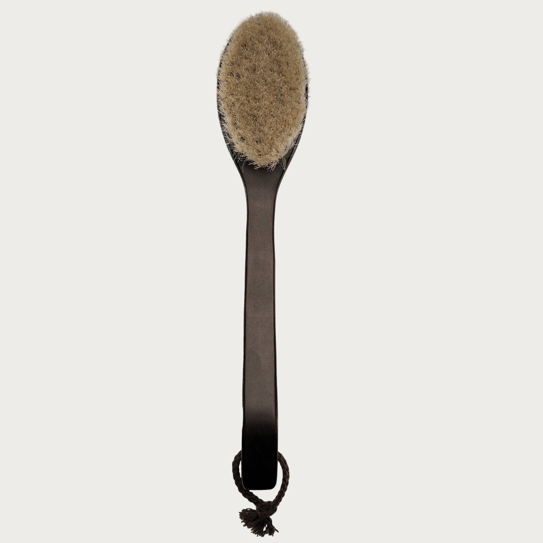 Long-handled brush with a round, bristled head on a white background