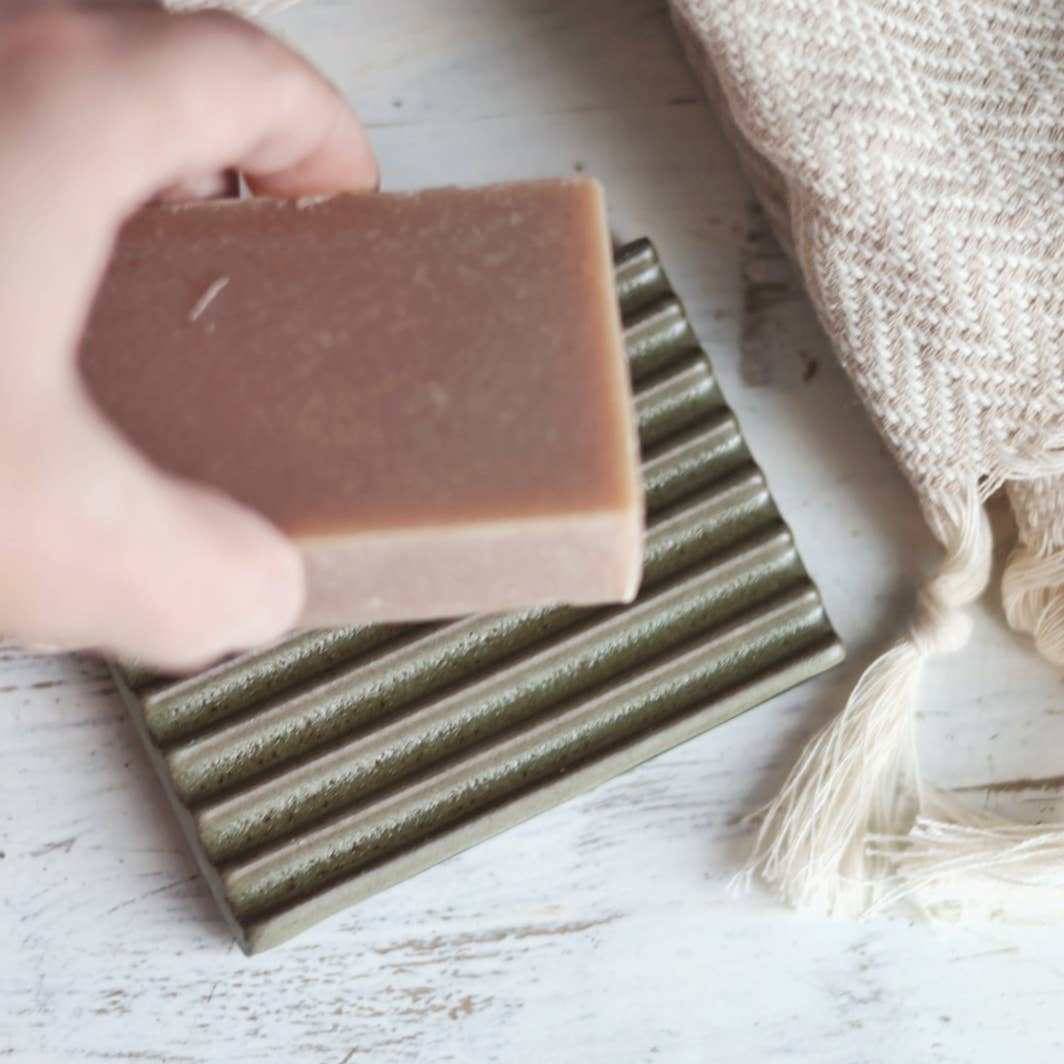 Handmade soap bars on a wooden surface with a textured cloth.