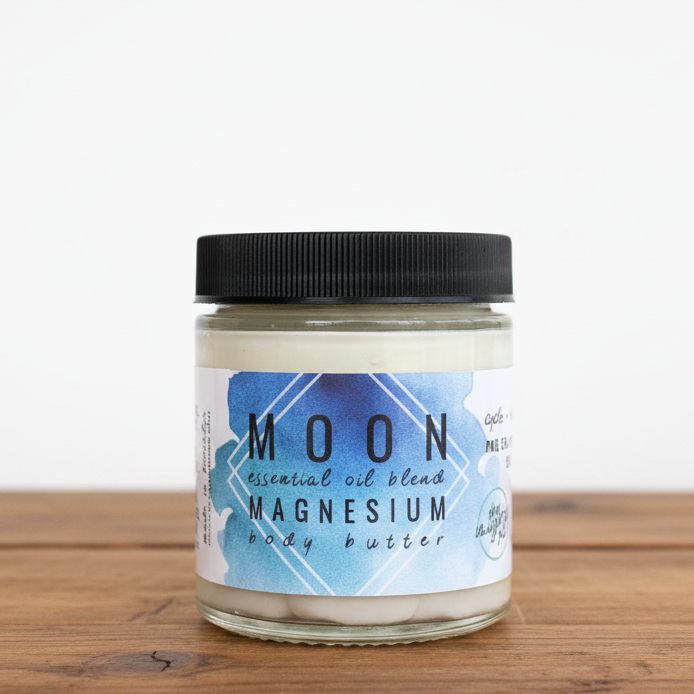 A jar of MOON brand magnesium body butter with a label indicating it is essentials oil blend, not suitable for pregnancy or breastfeeding, and with essential oils. The jar is clear with a black lid and a label that includes the product name and a brief description.