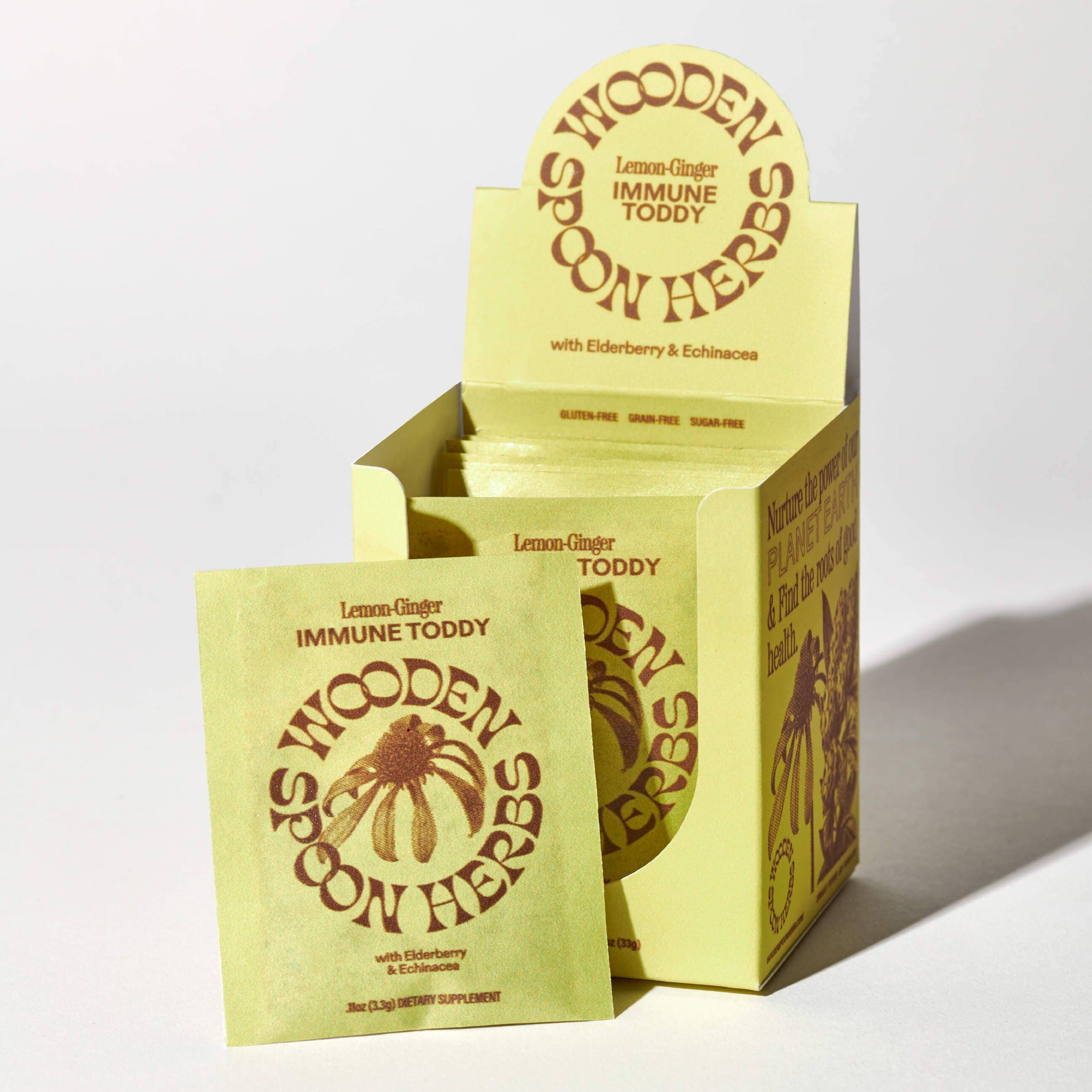 Yellow packaging of Wooden Spoon Herbs Lemon Ginger Immune Toddy on a white background