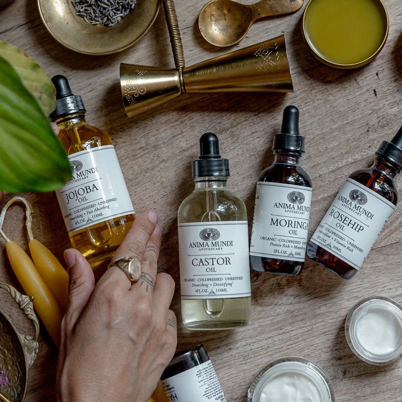 Wooden table with skincare products, including bottles and jars, with a hand reaching out.