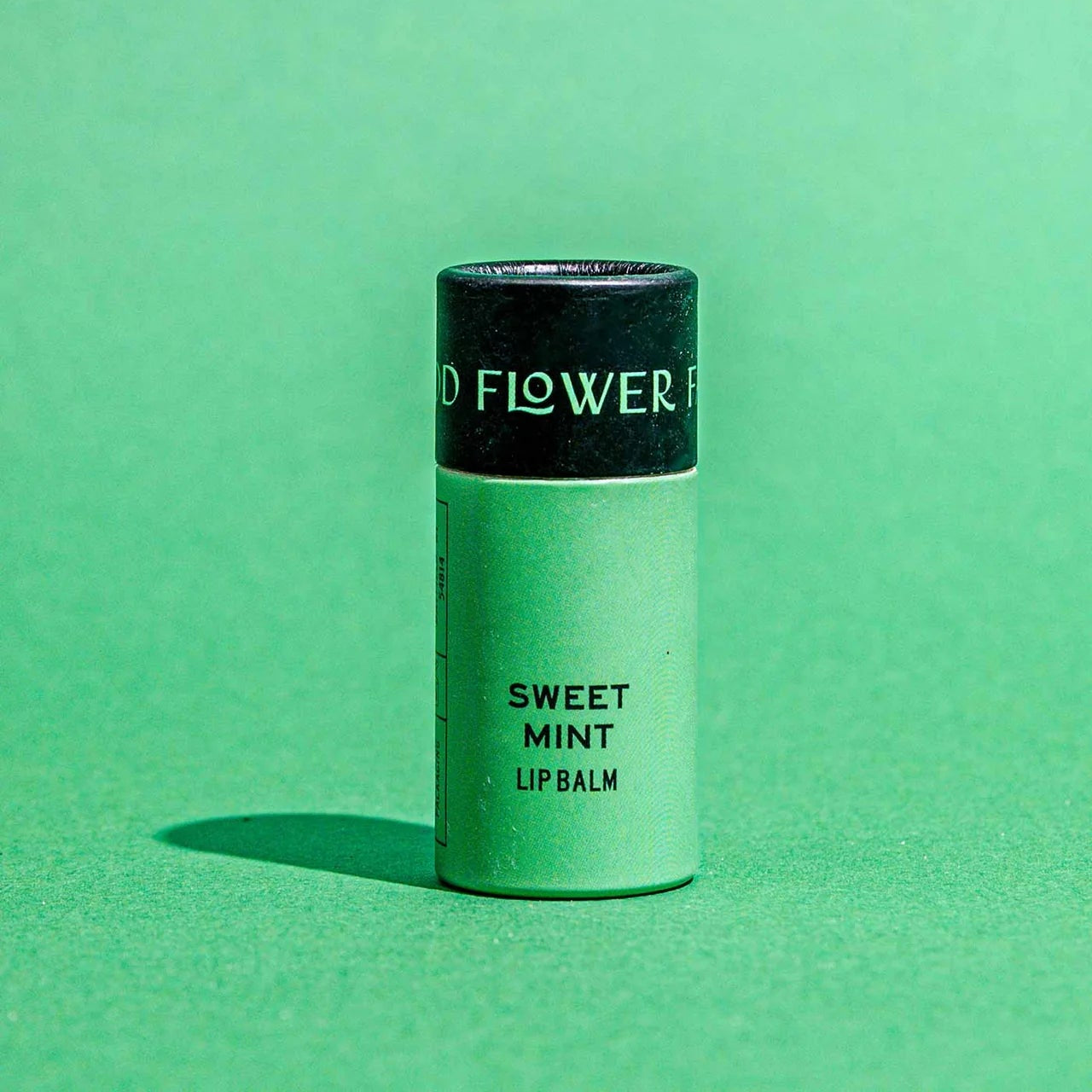 Lip balm container labeled 'Sweet Mint' on a green background