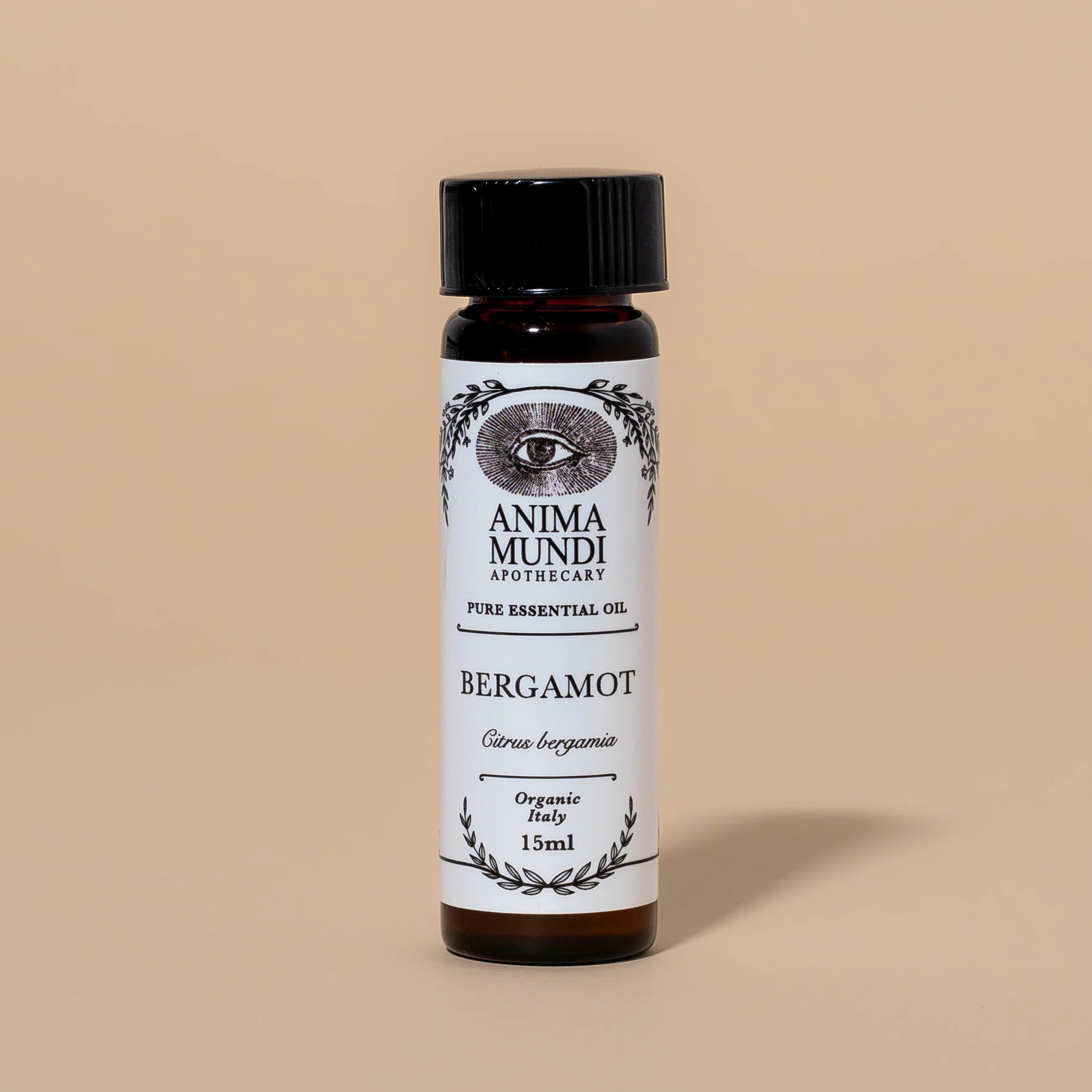 Bottle of Anima Mundi Bergamot essential oil on a beige background