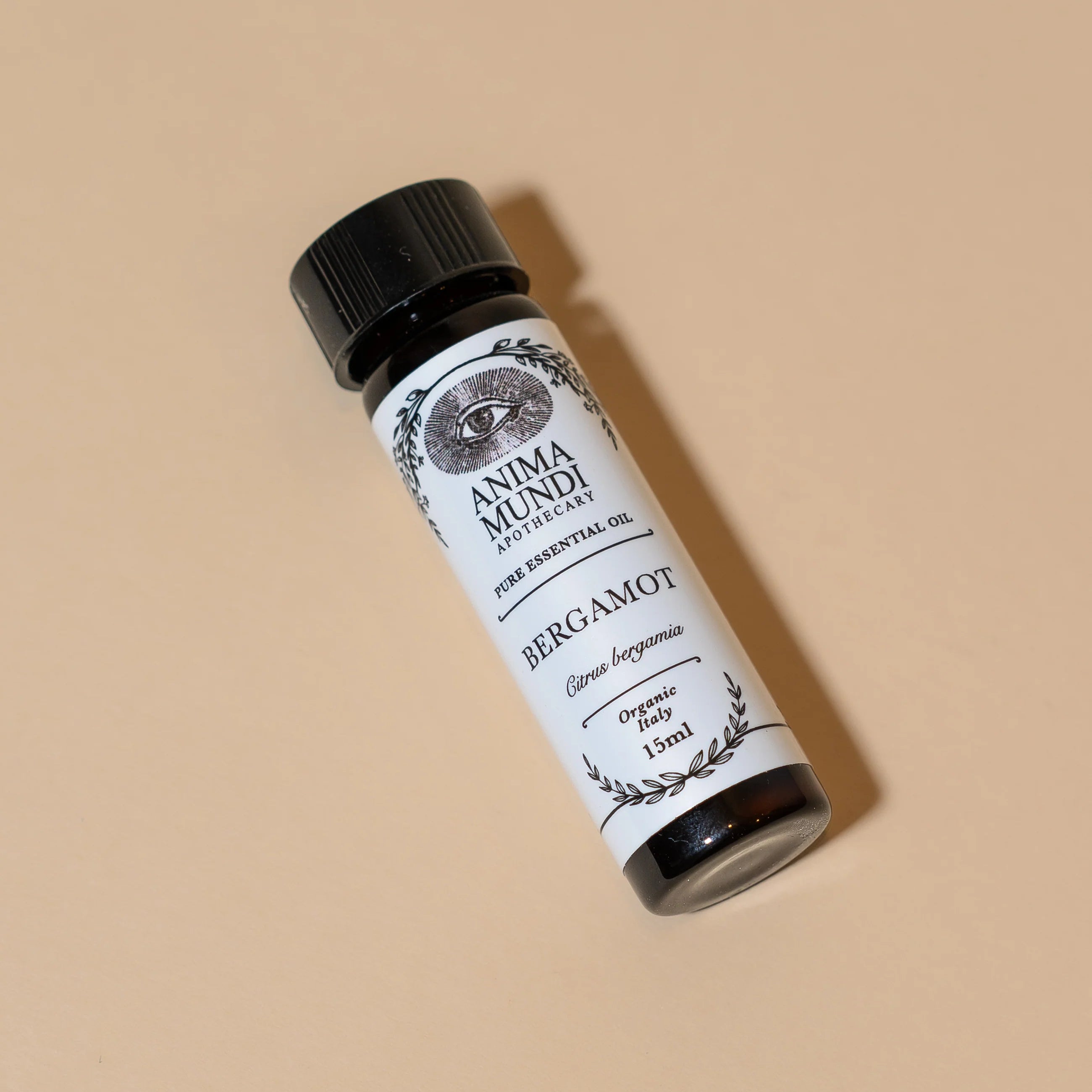 Bottle of Bergamot essential oil with a label on a beige background
