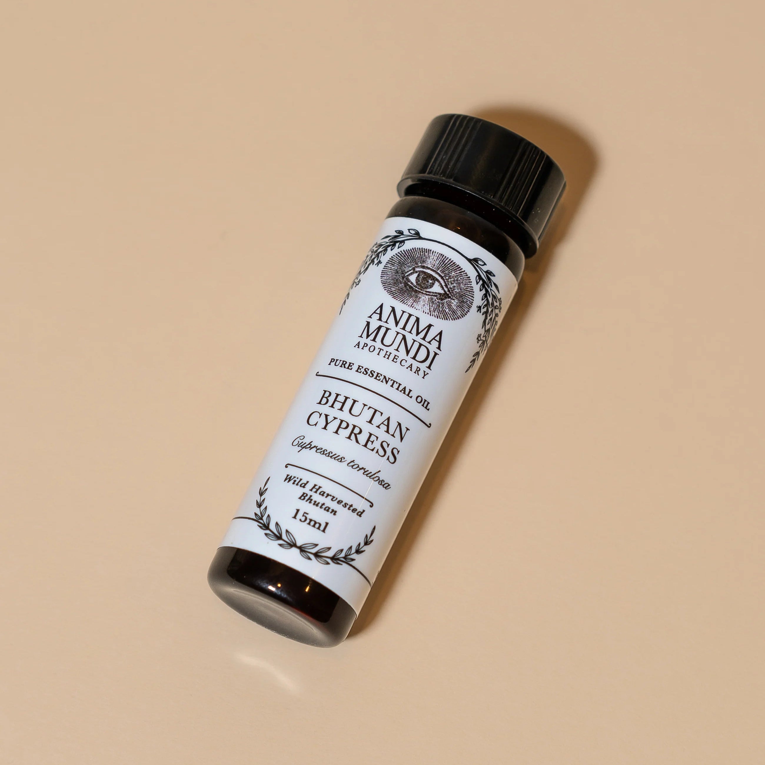 Anima Mundi Bhutan Cypress essential oil bottle on a beige background