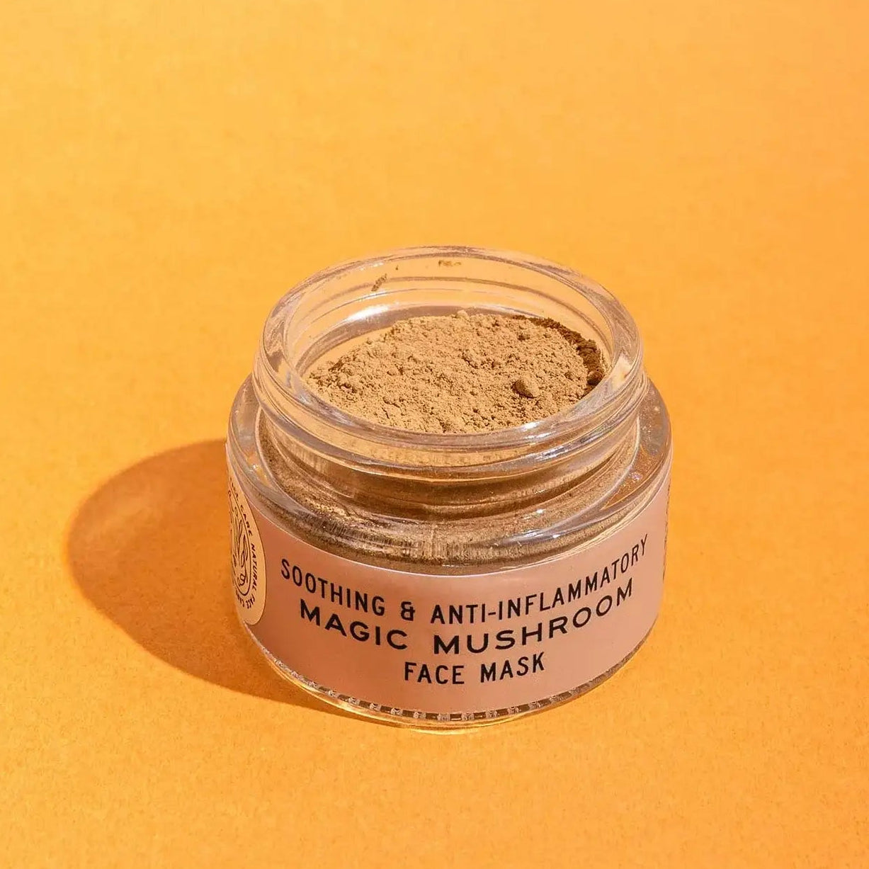 Jar of soothing and anti-inflammatory magic mushroom face mask on an orange background